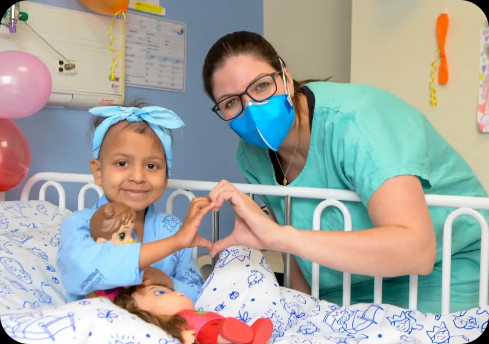 Menina paciente ao lado de médica do Hospital Pequeno Príncipe
