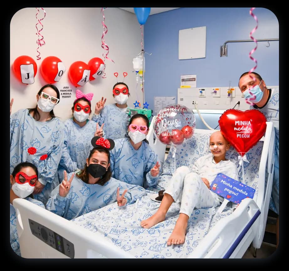 Menina com câncer sendo visitada no hospital com balões de coração