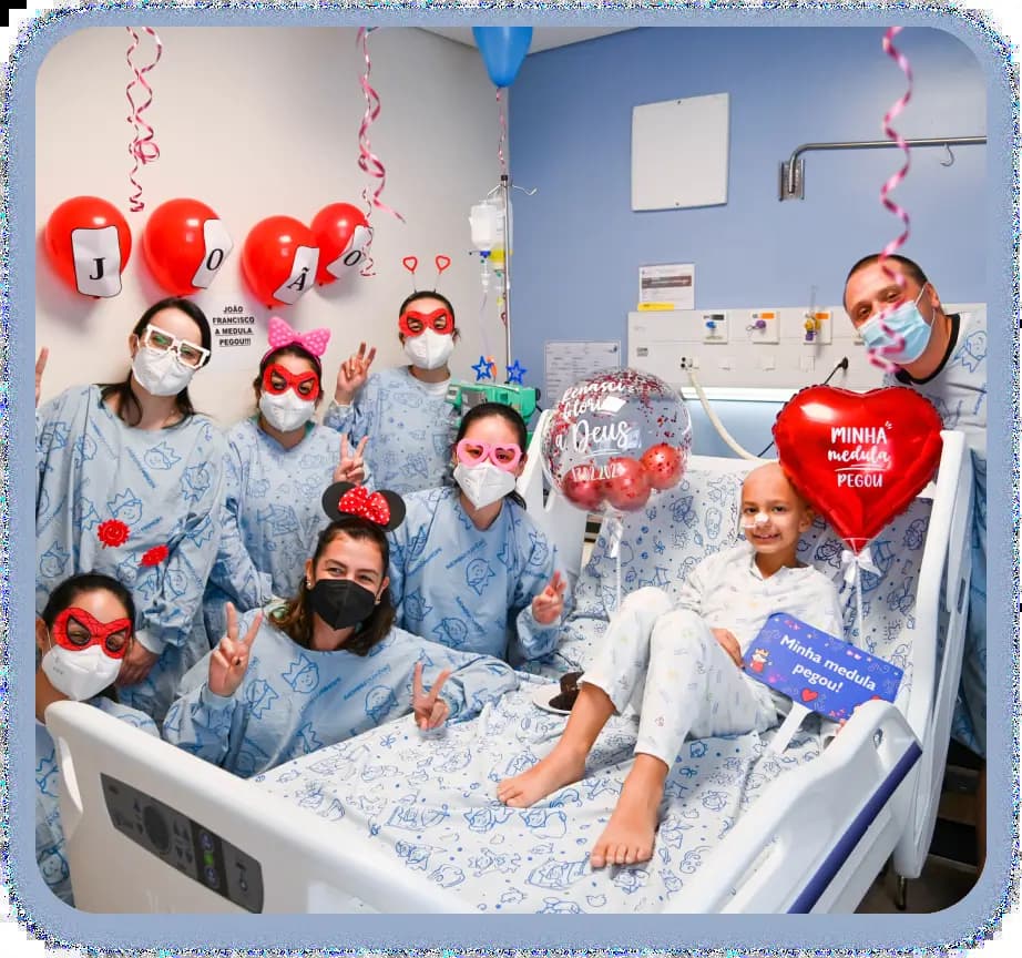 Menina com câncer sendo visitada no hospital com balões de coração