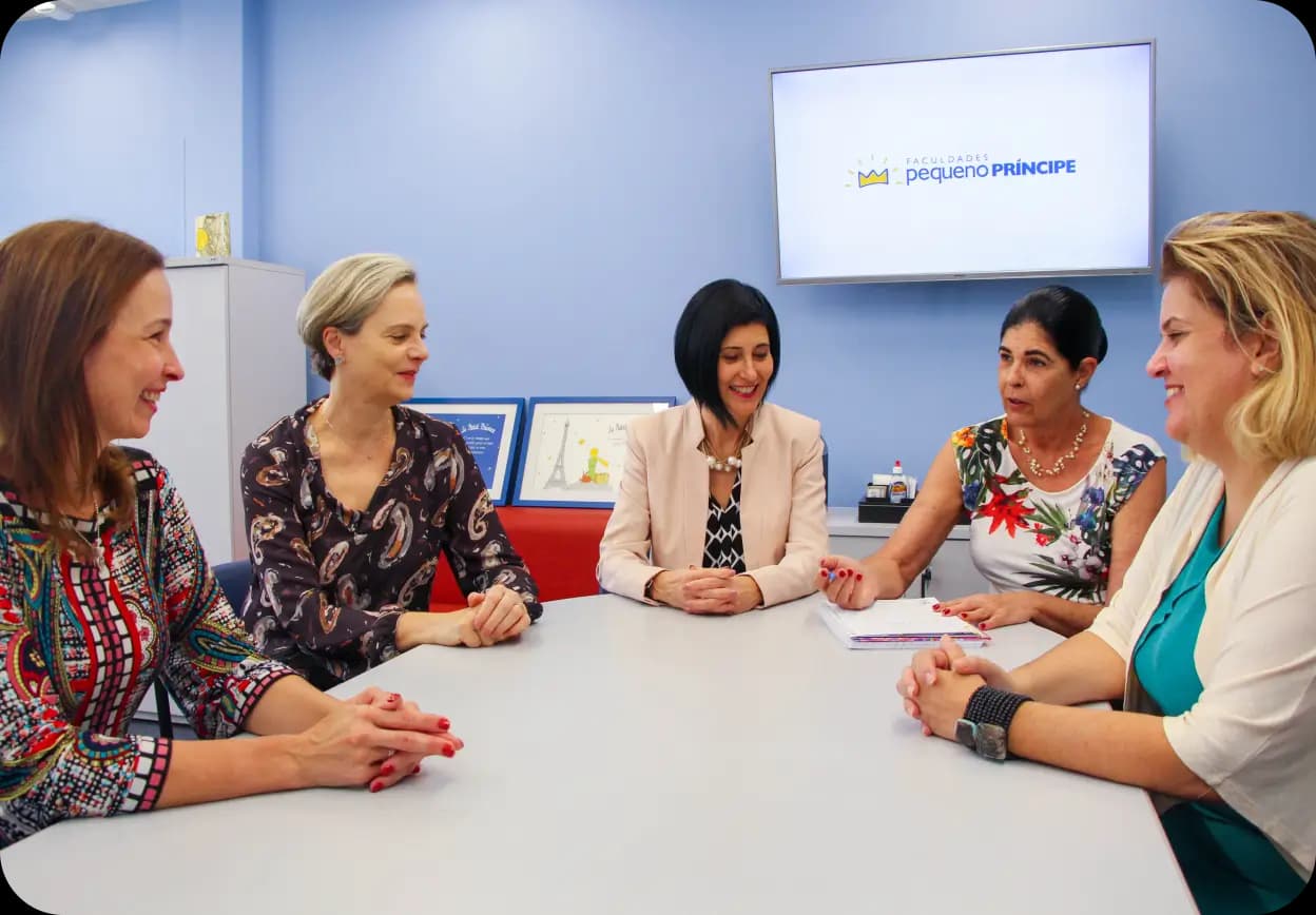 5 mulheres sentadas numa mesa conversando